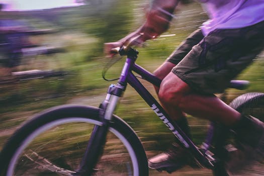 A vibrant motion capture of a cyclist biking outdoors, showcasing speed and action.