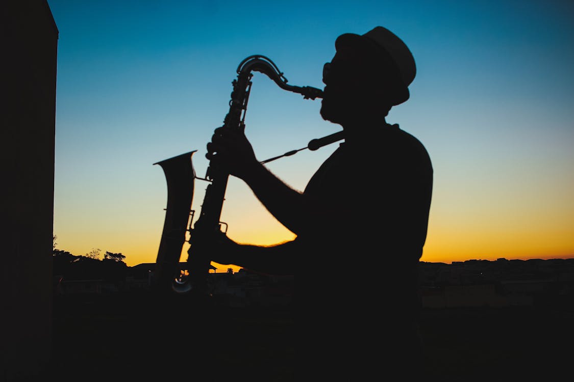 Hình Bóng Của Một Người đàn ông Chơi Saxophone Trong Buổi Hoàng ...