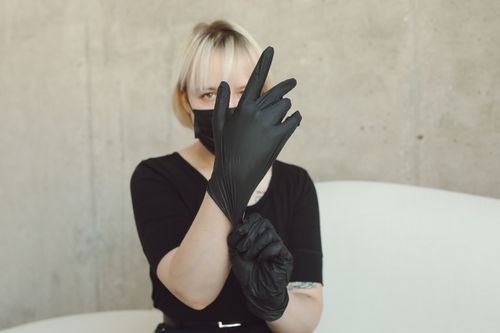 Free Caucasian woman with blond hair wearing black mask and gloves indoors, posing. Stock Photo