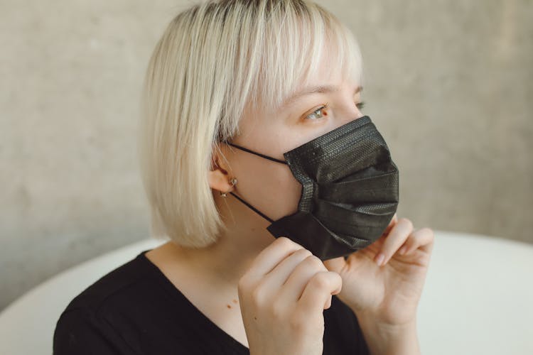 A Woman Fixing Her Face Mask On Chin