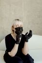 A Woman With Blond Hair Wearing Black Shirt and Face Mask