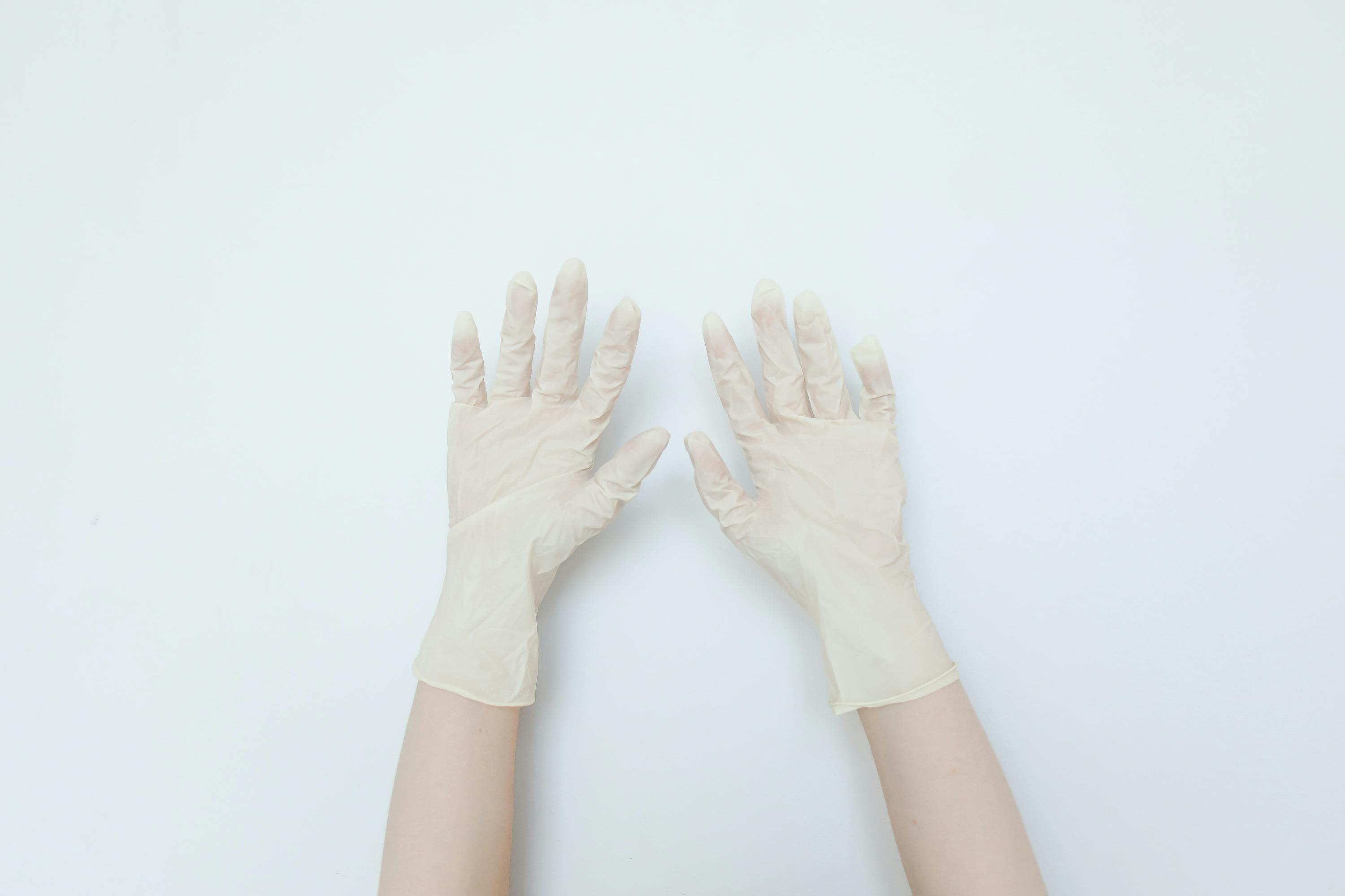 Free A minimalist top view of hands wearing latex gloves, symbolizing protection and hygiene. Stock Photo