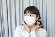Woman in White Long Sleeve Shirt Wearing White Mask