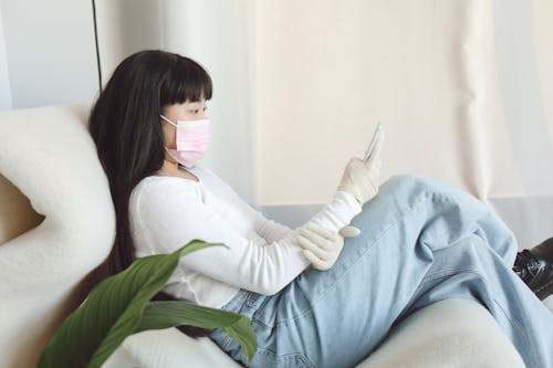 A Woman in white long Sleeves using a Smartphone