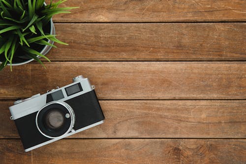 Free Black and Silver Film Camera on Brown Wooden Surface Stock Photo