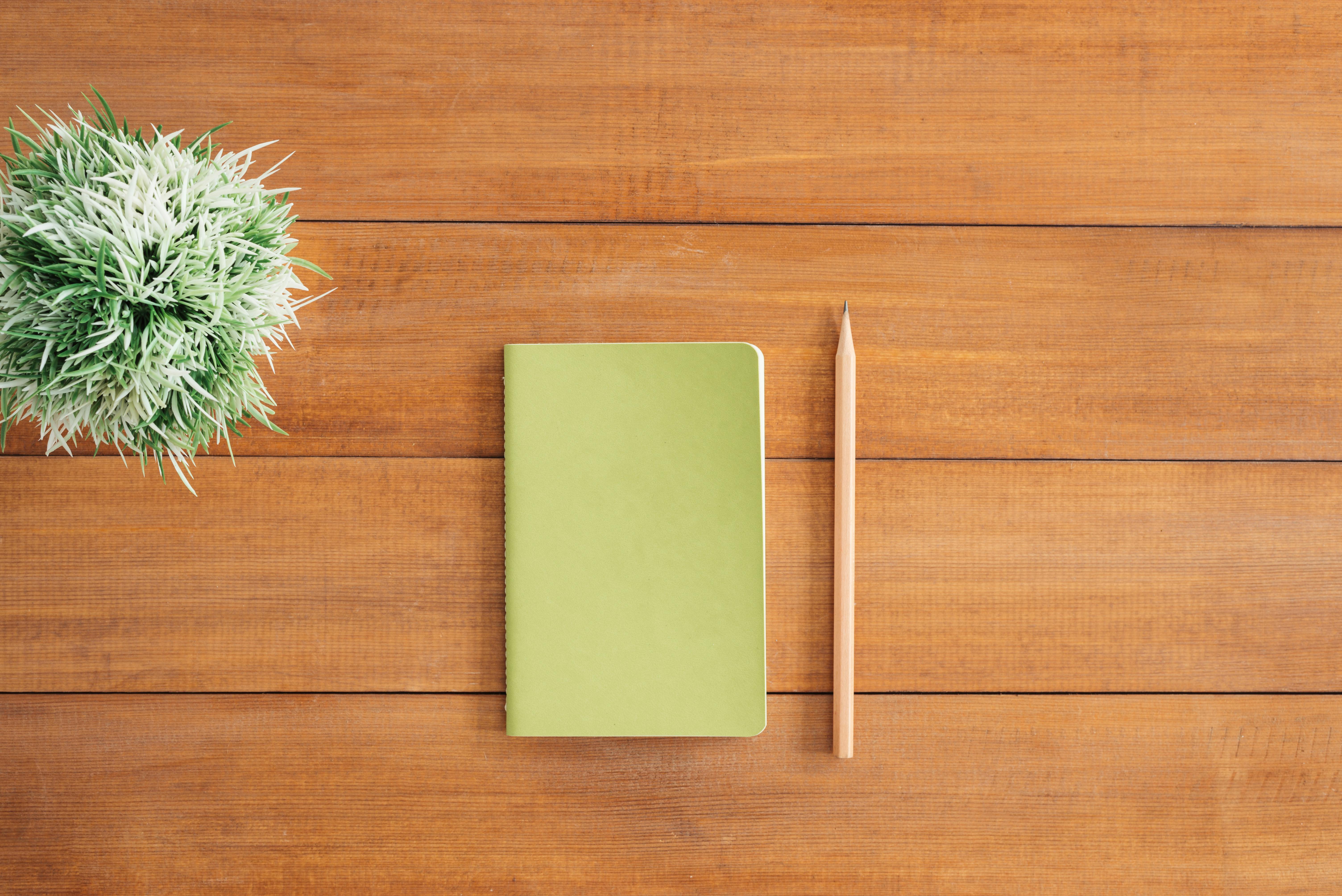 White Notes Beside a Pencil on Brown Wooden Surface