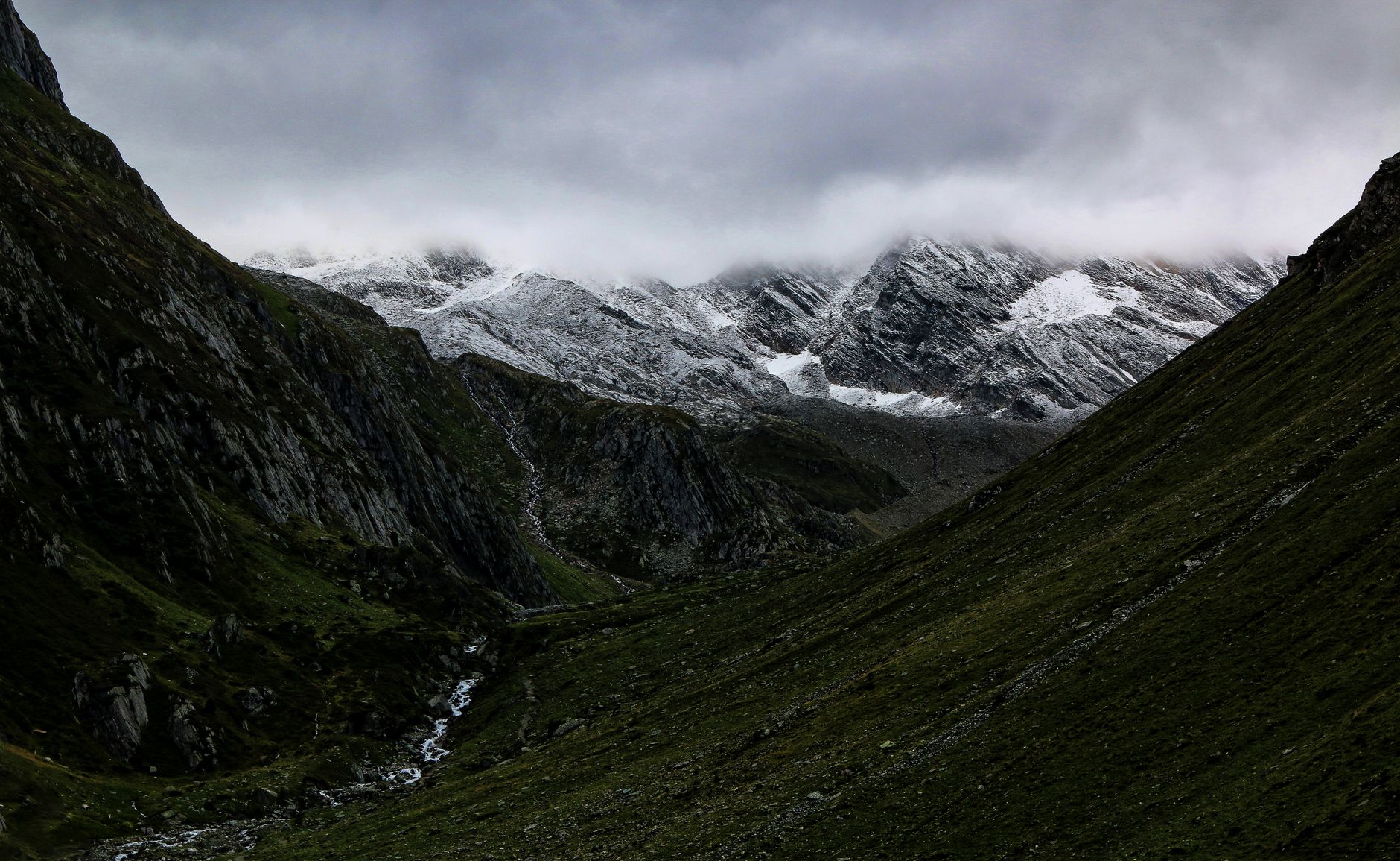 Explore stunning snow-capped mountains cloaked in mist with lush valleys below and dramatic skies above. — free online jigsaw puzzle on JigsawPuzzlesFreeOnline.org