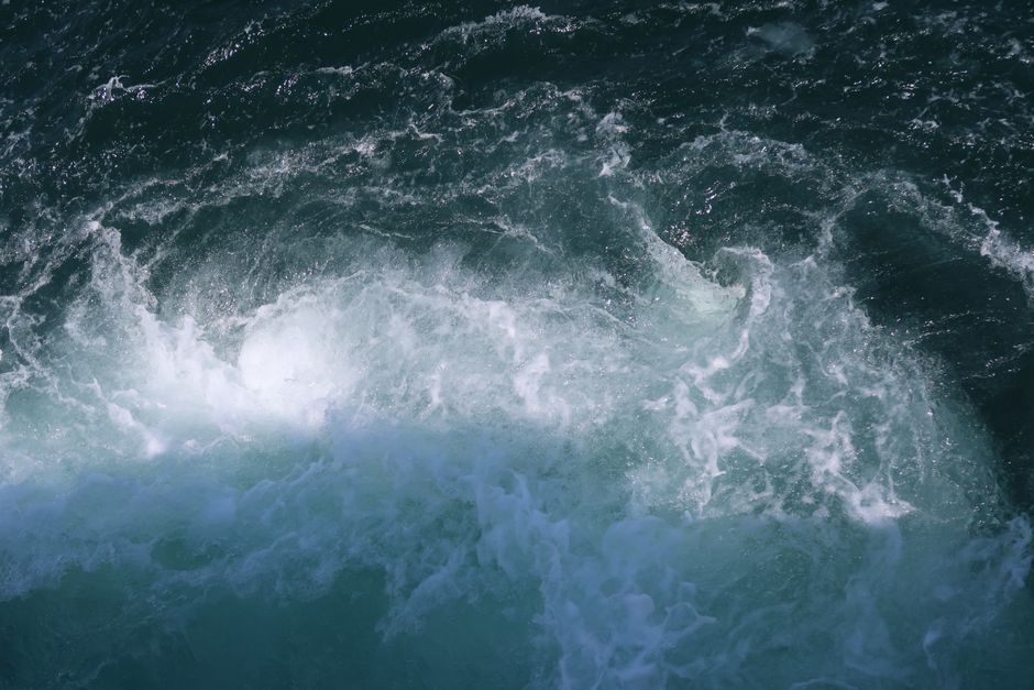 High-angle view of powerful ocean waves creating dynamic patterns and movement.