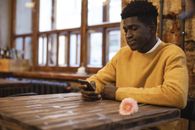 Man in Yellow Sweater Sitting on Chair