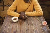 Man in Yellow Sweater Holding Smartphone