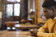 Man in Yellow Long Sleeve Shirt Holding Smartphone