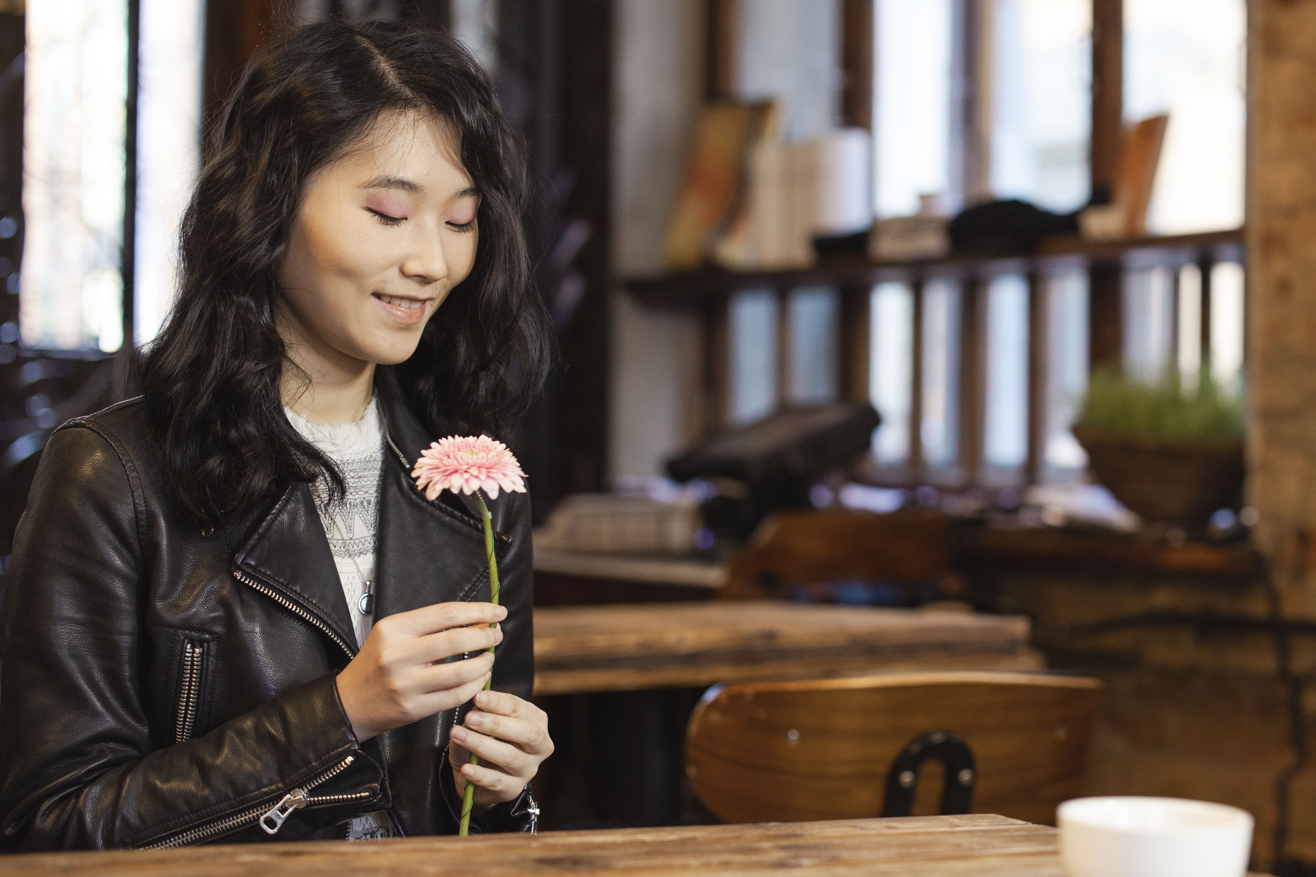 Woman in Black Leather Jacket Holding a Pink Flower · Free Stock Photo