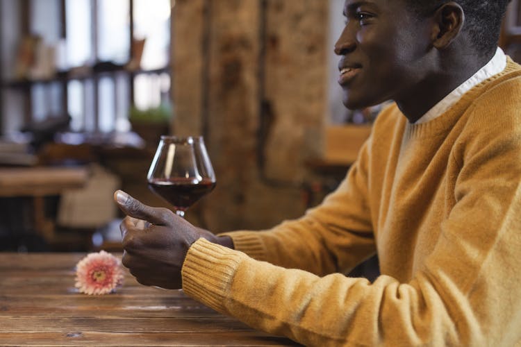 Man Sitting At A Table And Drinking Red Wine 