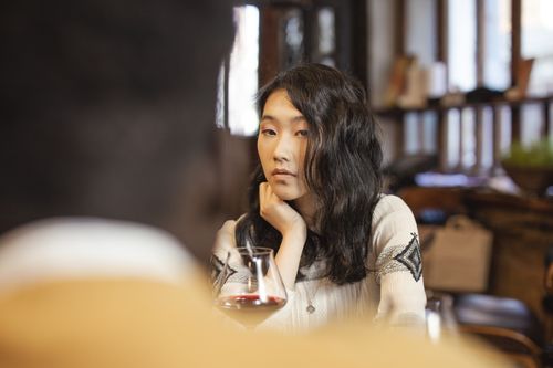 Free Serene young woman reflecting while enjoying a glass of wine in a cozy indoor setting. Stock Photo