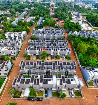 A vibrant aerial view capturing the modern residential complexes in Banten, Indonesia, amidst lush greenery.