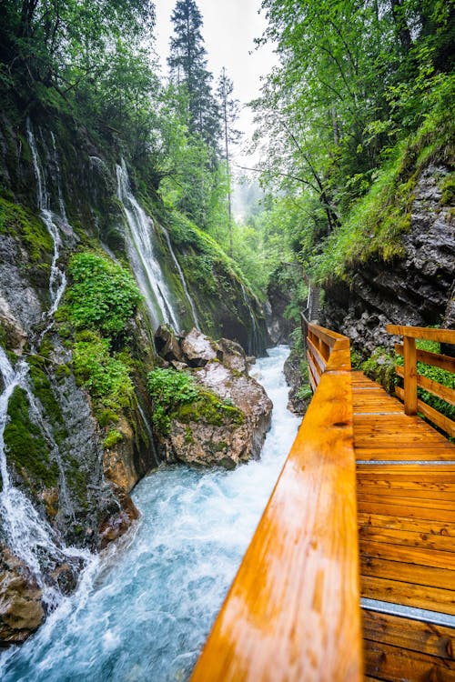 Brown Wooden Bridge beside Flowing River