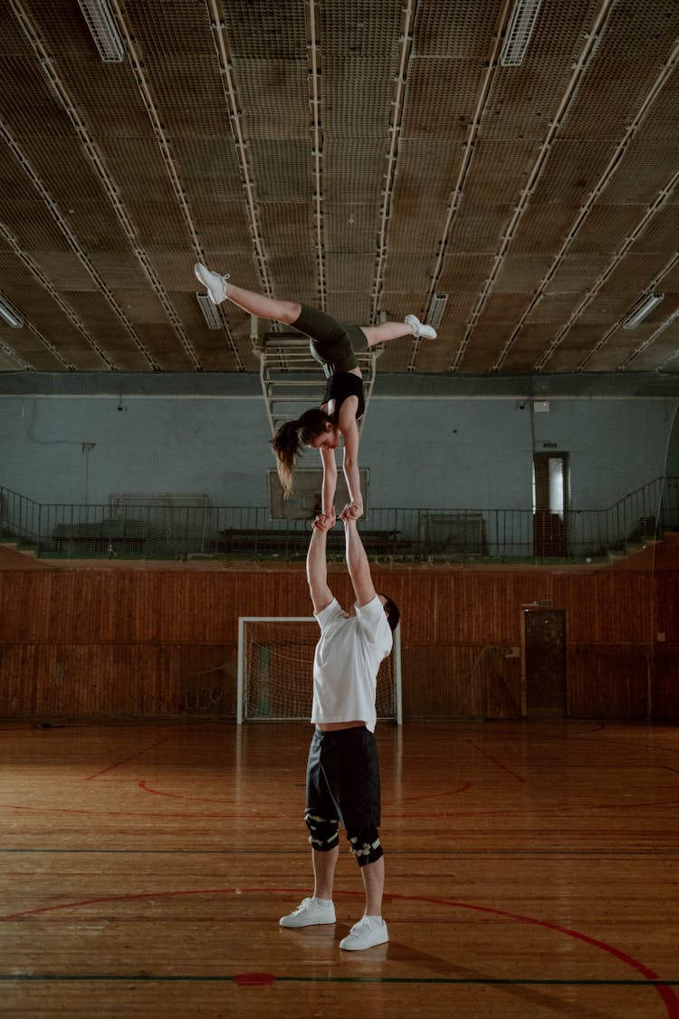 Female Cheerleader Doing A Stunt Supported By A Male Cheerleader 