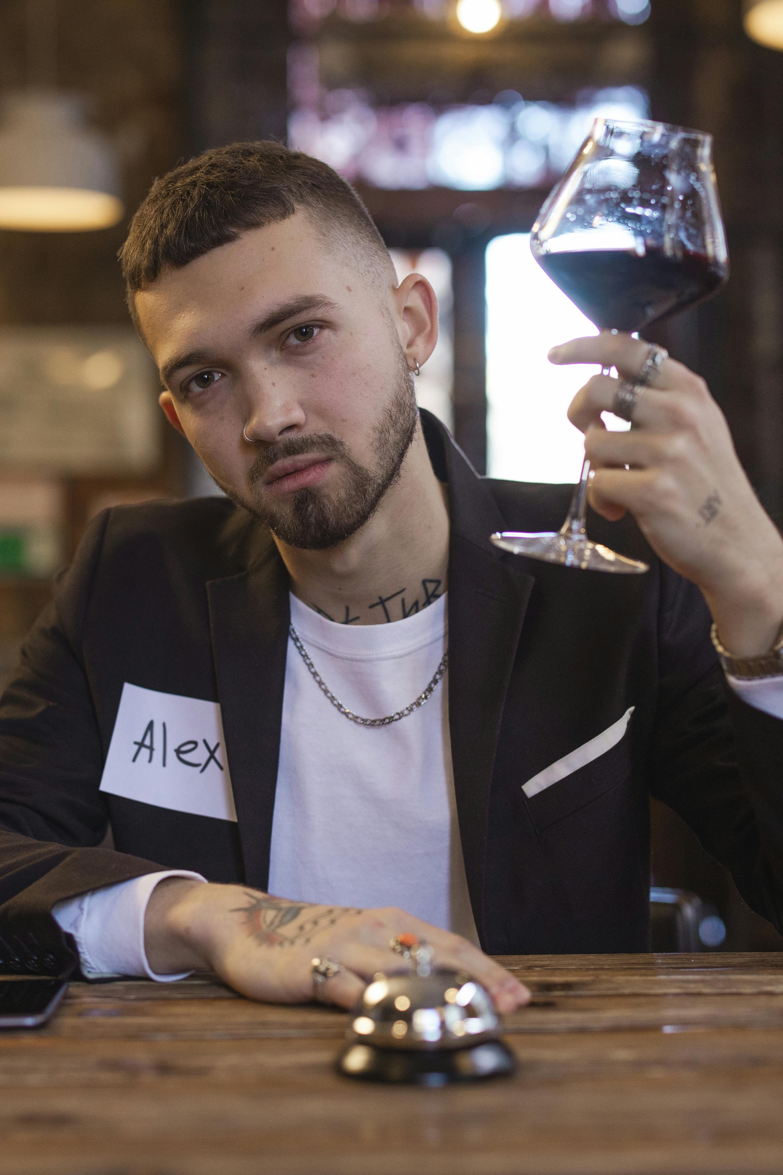 Man holding a wine glass. | Photo: Pexels