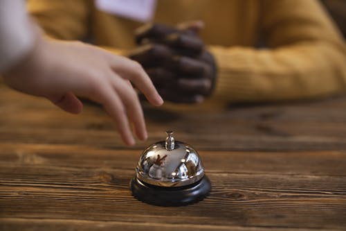 A Silver Reception Bell on the Wooden Table