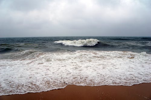 多雲的, 岸邊, 波浪撞擊 的 免费素材图片