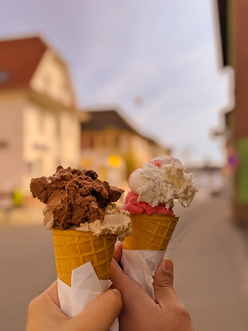 Crop persons with ice creams