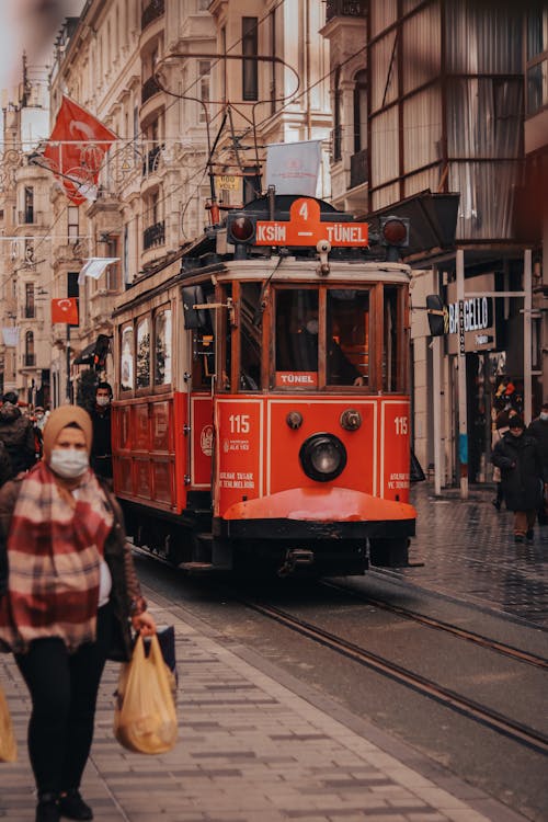 People Walking Near Red Tram on the Street