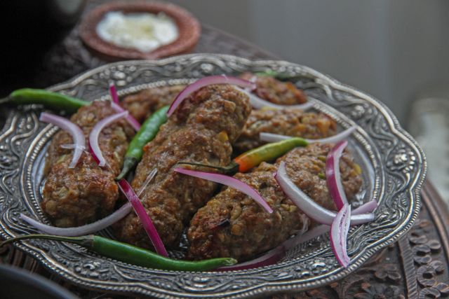 Savor the flavors of grilled kebabs served with onions and green peppers on a silver platter.