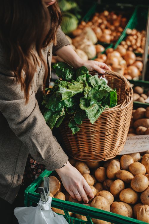 Free A woman selecting fresh produce at an outdoor market in Erfurt, Germany. Stock Photo