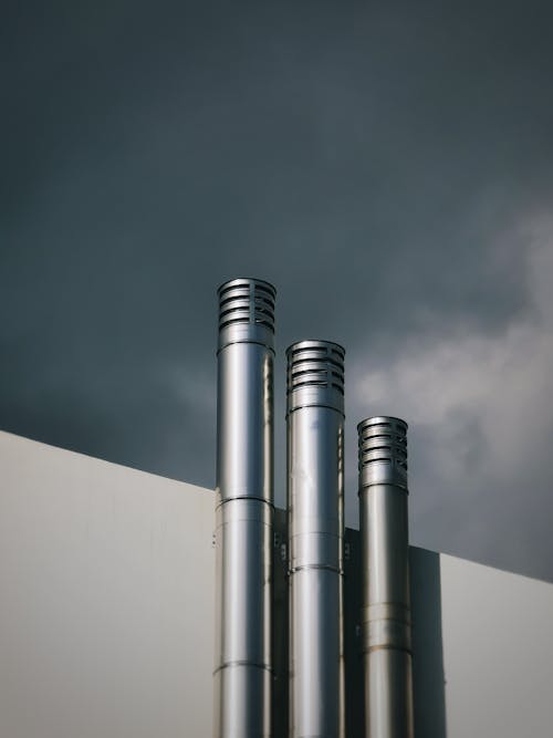 Free Stainless Steel Exhaust Pipes on Concrete Wall Stock Photo