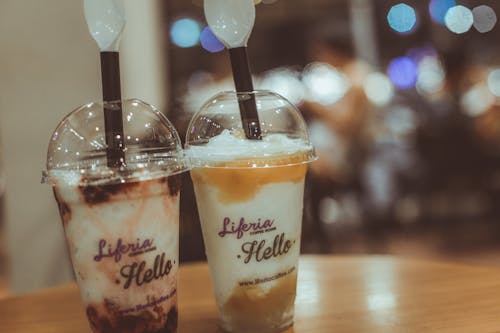Free Two Liferia Hello Coffee Drinks on Brown Wooden Table Stock Photo