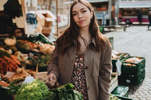 Woman in Brown Coat Holding Green Vegetable