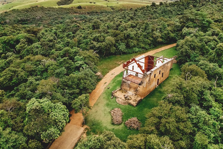 Old Church During Restoration On Lawn Between Lush Trees