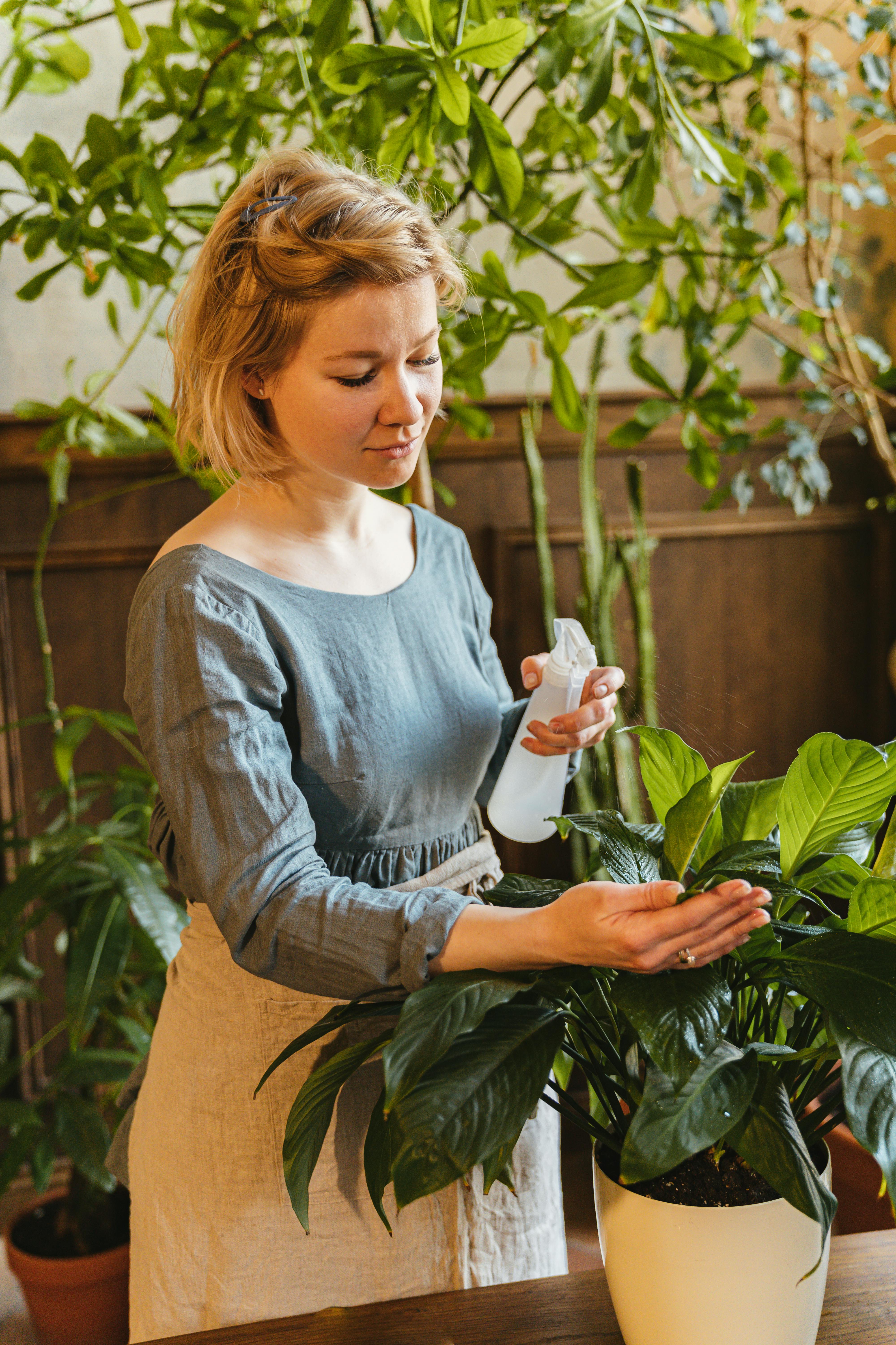 a woman watering a plant