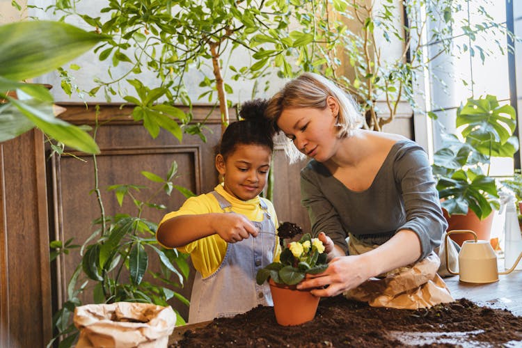 Woman And Child Planting On A Clay Pot