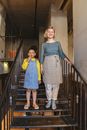 A Child and a Woman Standing on a Stairway