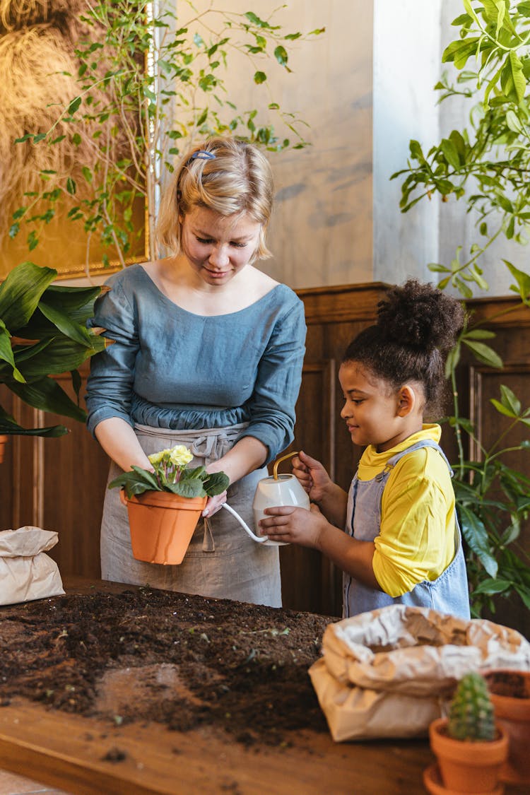 A Child Watering A Plant