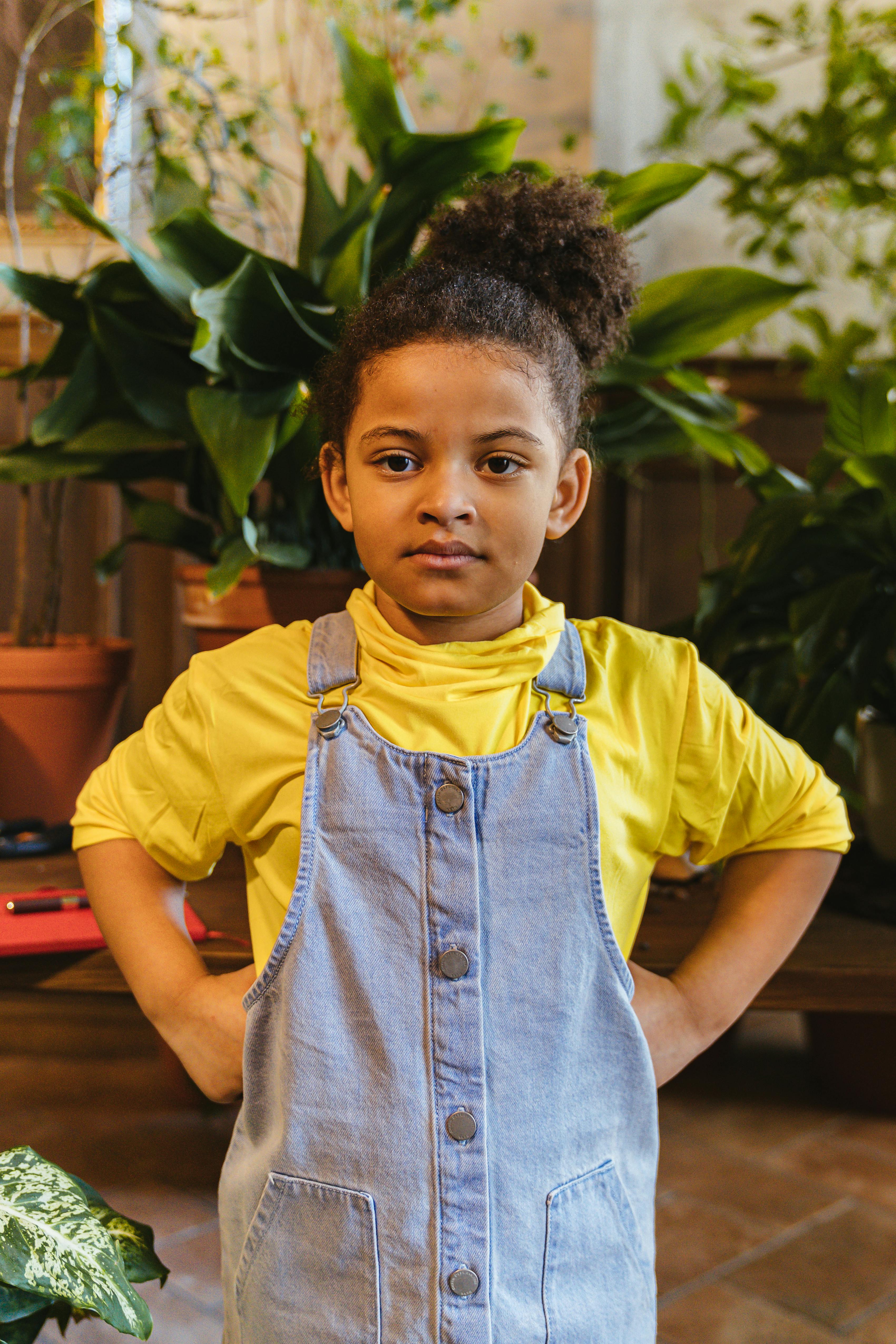 little girl standing near the potted plants