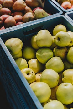 Vibrant green apples displayed in colorful crates at a local market in Erfurt, Germany.