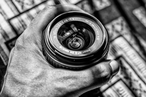 Dslr Zoom Lens Tutan Kişinin Gri Tonlamalı Fotoğrafı