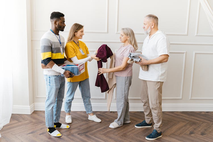 Volunteers Giving Donations To Elderly People