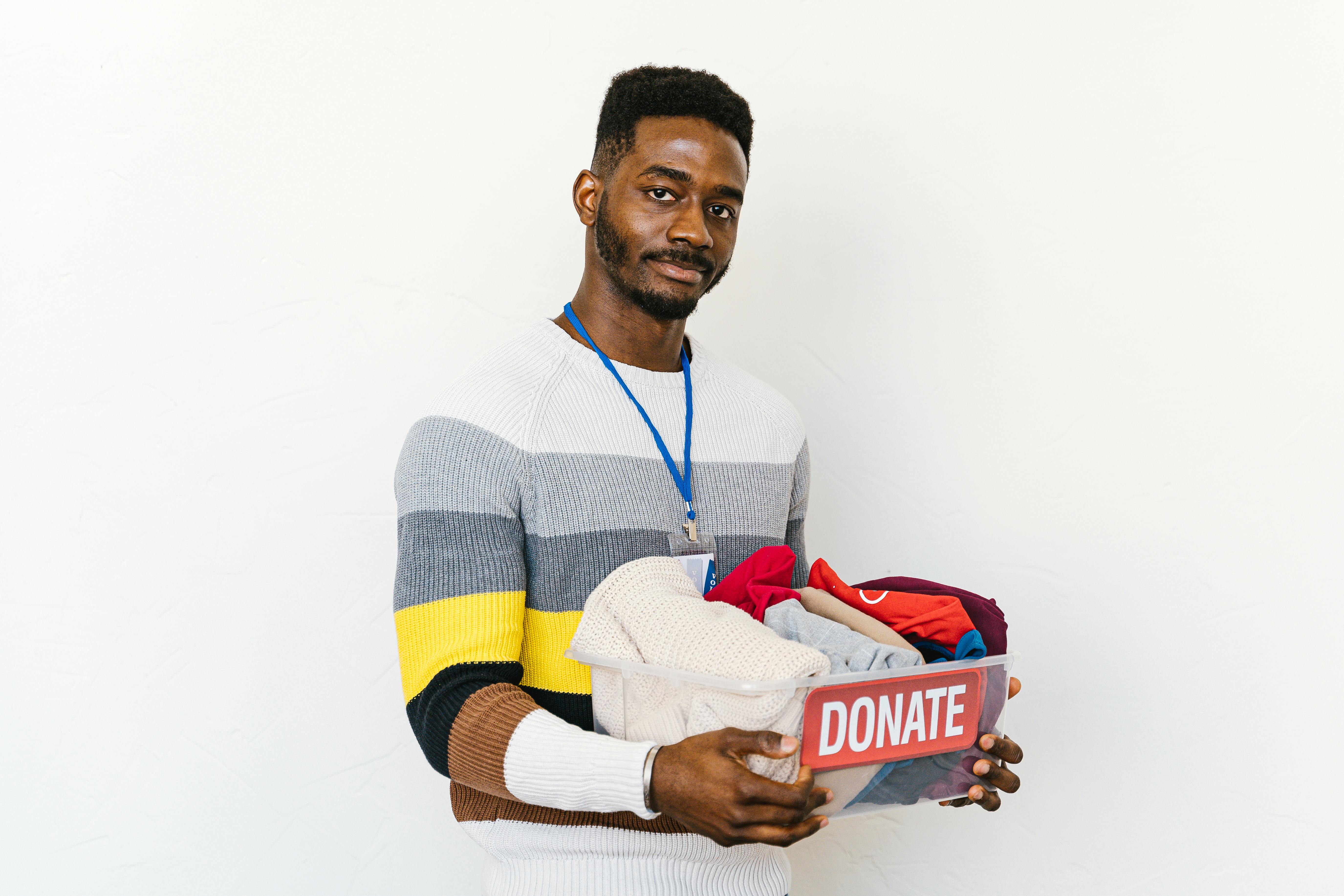A person holding a box of clothes while posing for a picture