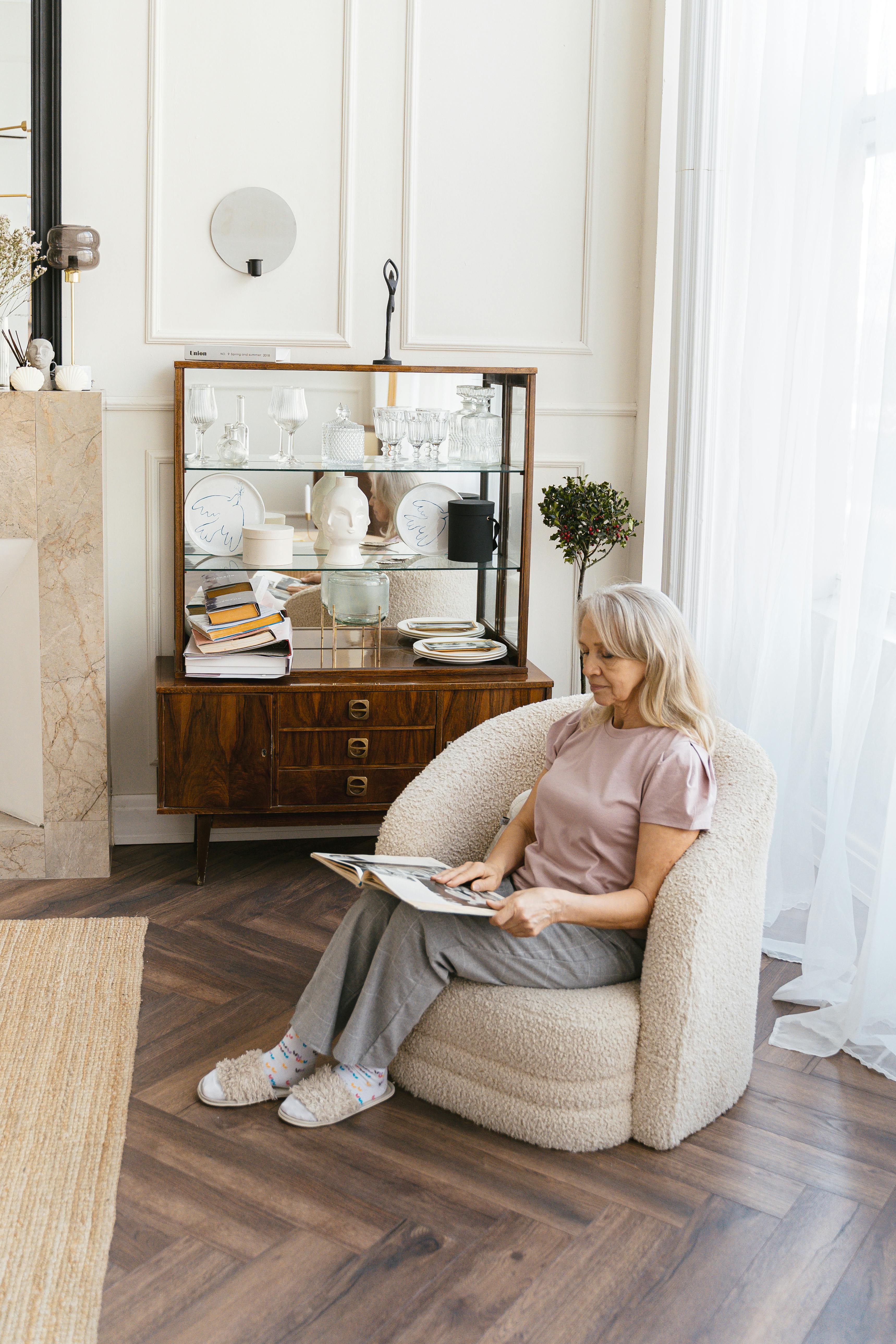 woman sitting on sofa chair reading a book