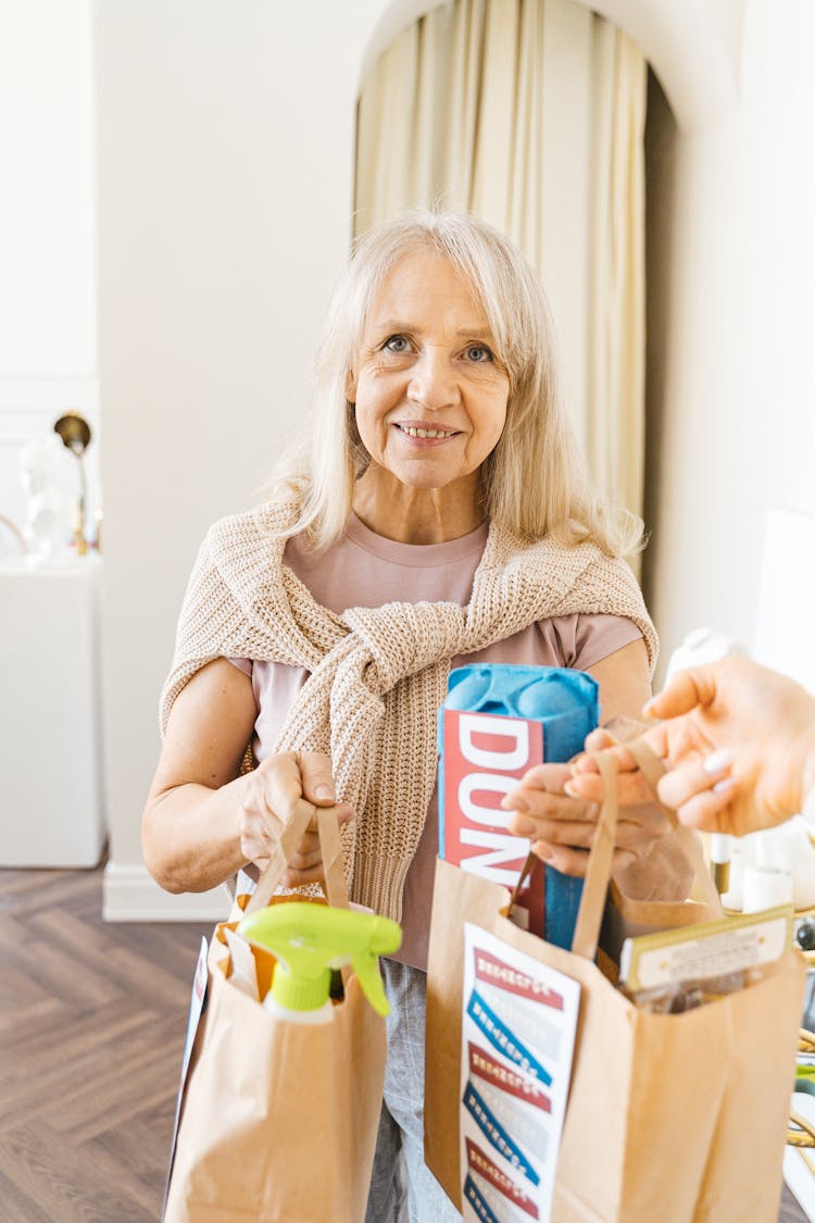 Elderly Woman Receiving Paper Bags Of Groceries