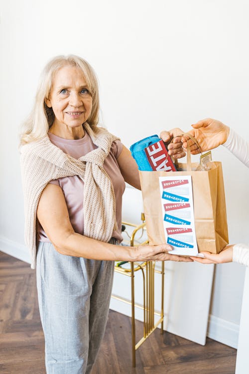 Elderly Woman Receiving a Paper Bag of Groceries