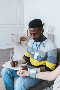 Male doctor sits with patient, taking notes and measuring blood pressure in a calm office setting.