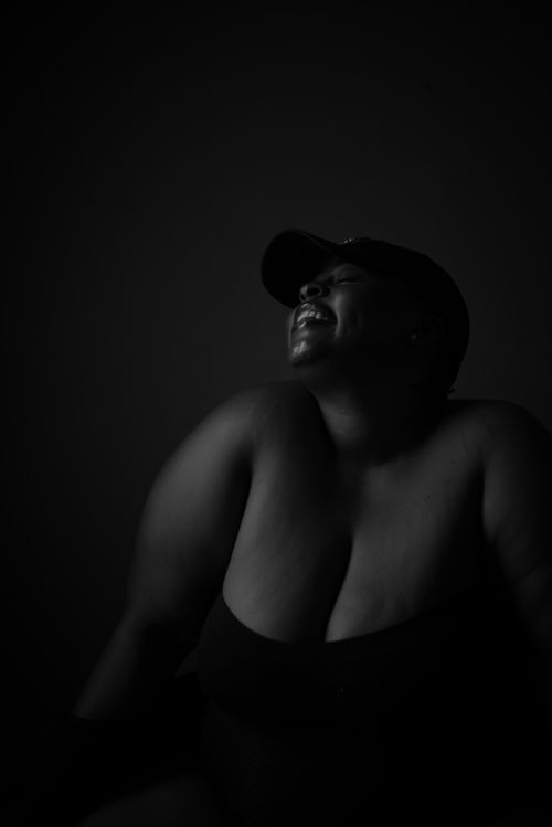 Free Black and white portrait of a woman joyfully smiling, captured in soft lighting, showcasing natural beauty. Stock Photo