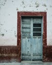 Blue Wooden Door on White and Red Concrete Wall