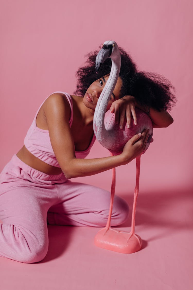 Woman In Pink Crop Top Holding Onto A Pink Flamingo