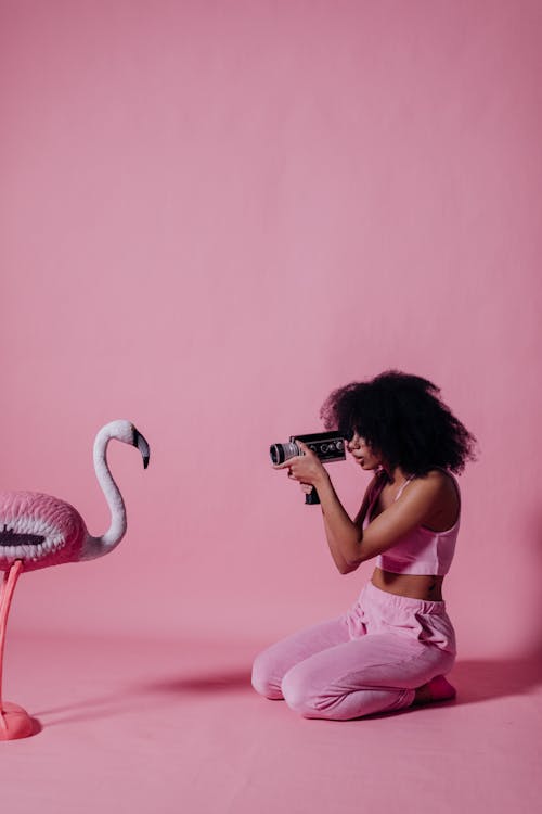 Woman in Pink Crop Top Recording a Pink Flamingo