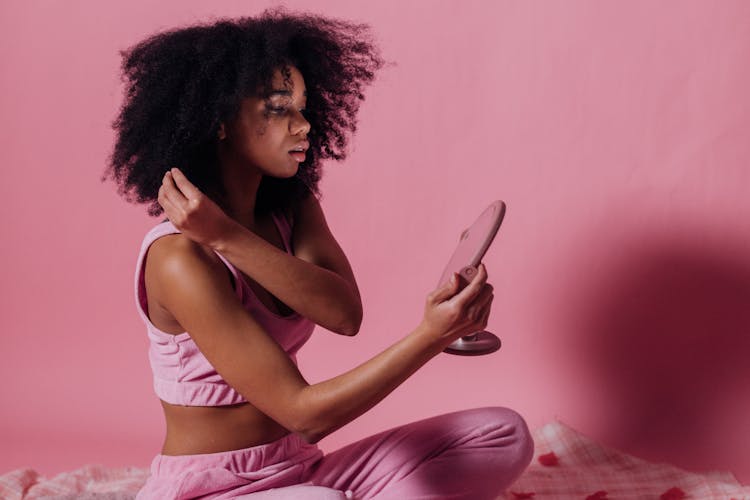 Woman In Pink Crop Top And Jogging Pants Looking At The Mirror